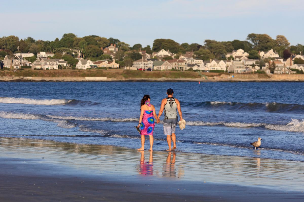 Visitors walking along Easton's Beach in Newport