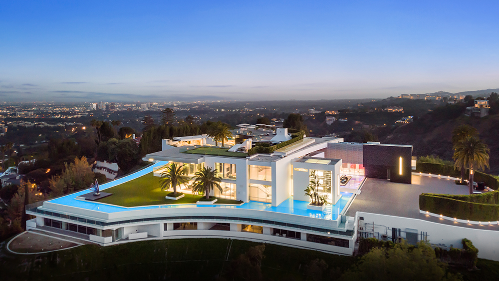 Luxury mansion illuminated above a city at dusk