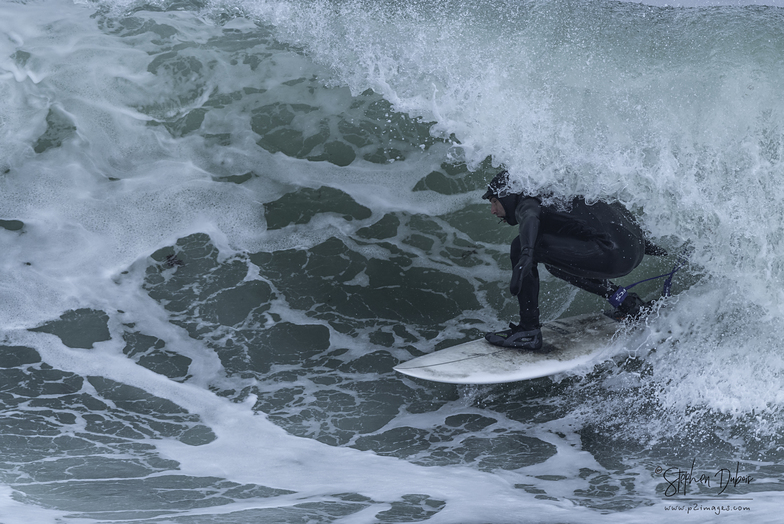 Surfer riding a powerful wave near Monahan's Dock