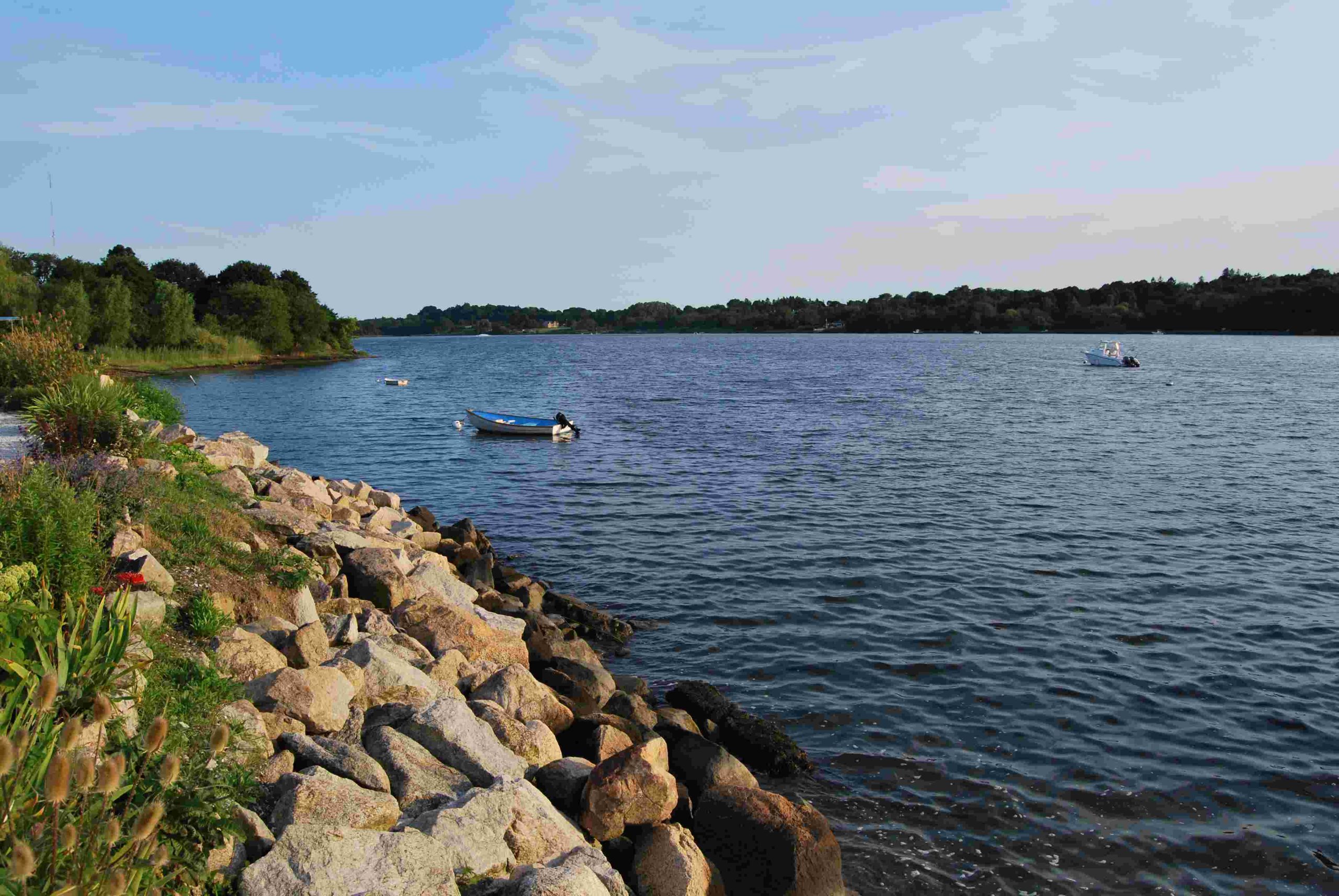 Rocky shoreline and calm water at Nannaquaket Pond in Tiverton