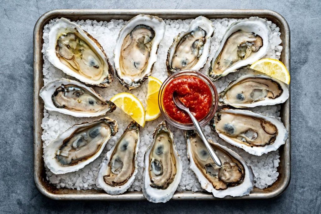 Fresh oysters on ice with lemon and cocktail sauce