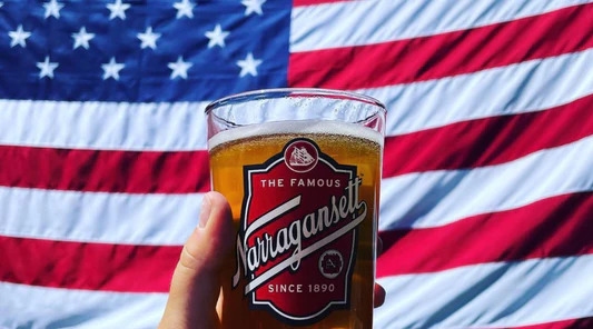 Glass of Narragansett beer in front of an American flag